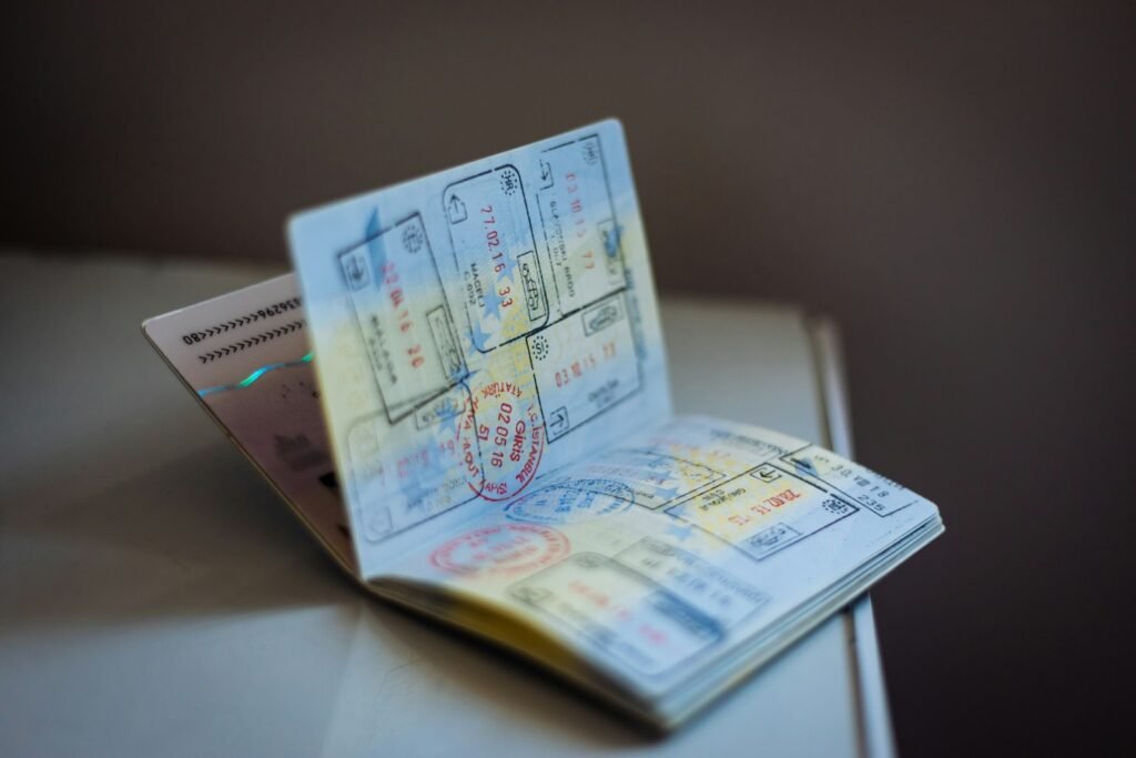 An open passport with numerous ink stamps on the pages on a table