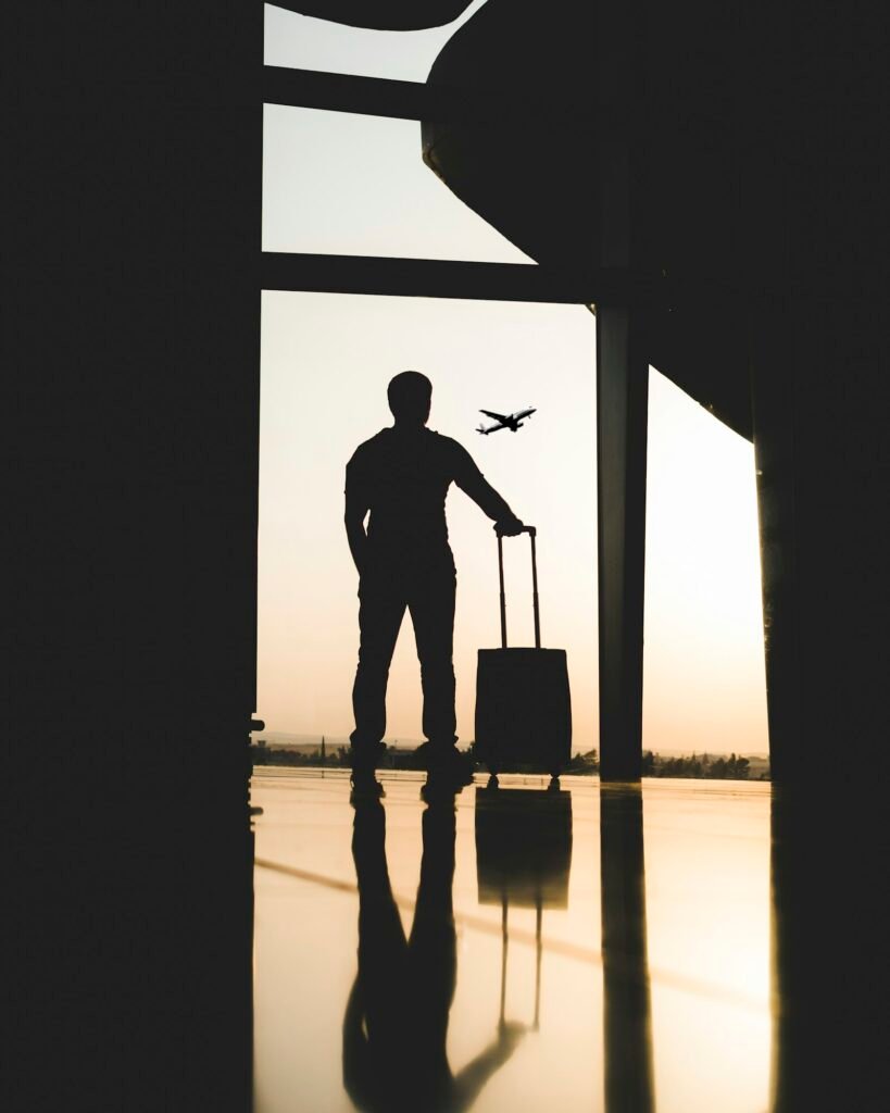 Silhouette of a traveller with luggage inside an airport