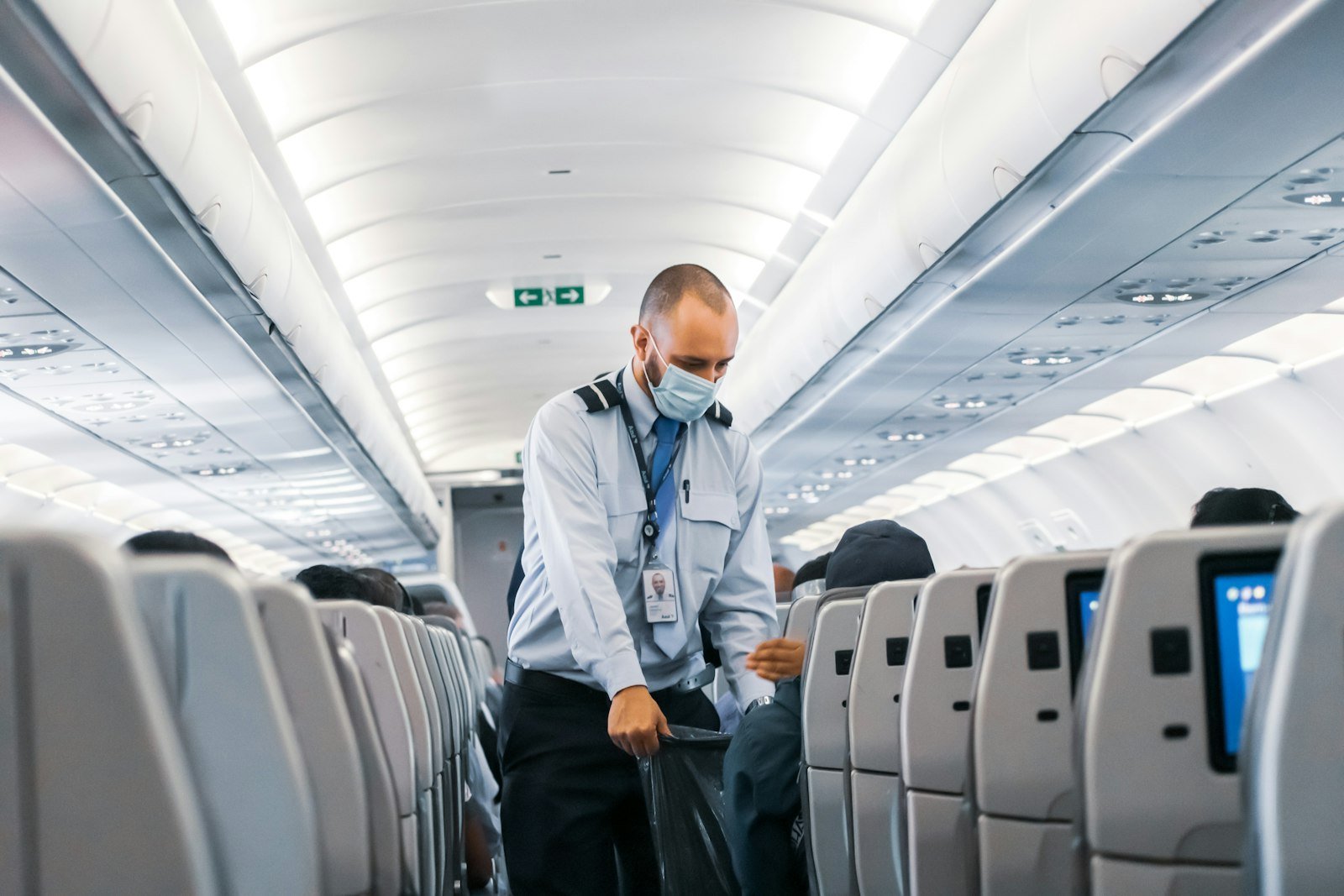 Passenger standing in the aisle of a plane to stretch on a long flight